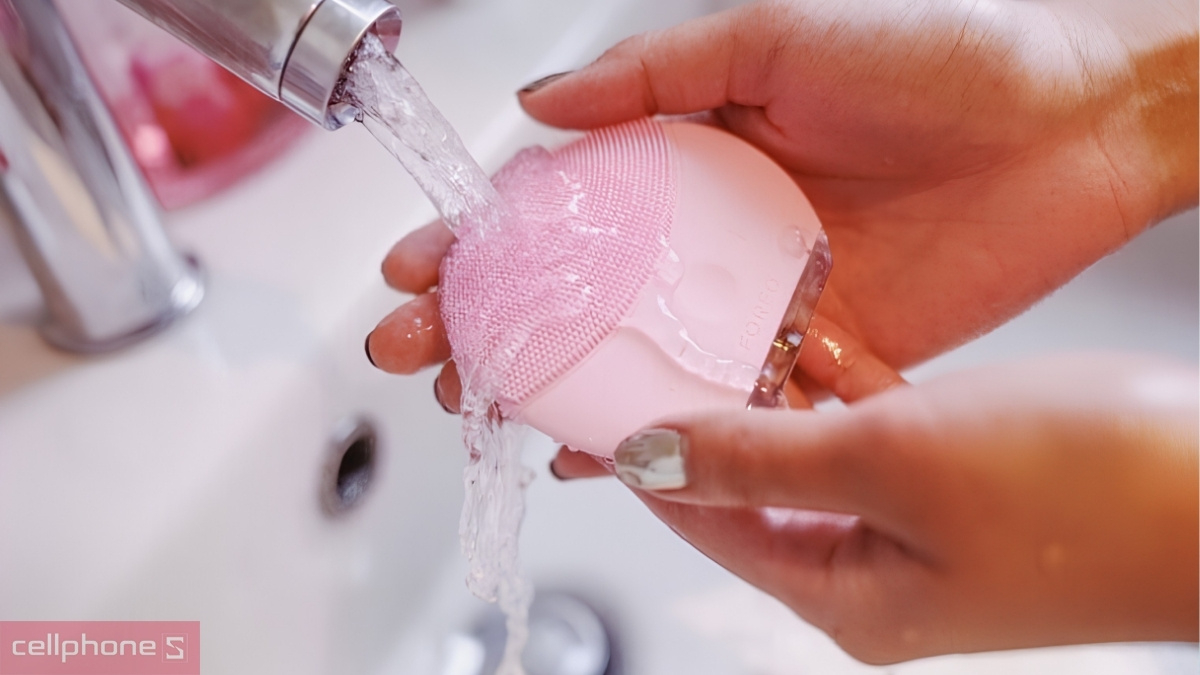 Vệ sinh đầu cọ máy rửa mặt Emmié dưới vòi nước sau mỗi lần sử dụng
