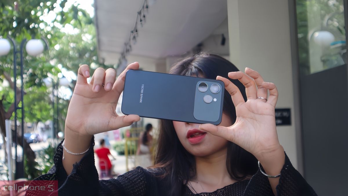 Bạn nữ cầm ngang điện thoại TECNO Spark màu đen chụp ảnh trải nghiệm camera công nghệ mới Bạn nữ cầm ngang điện thoại TECNO Spark màu đen chụp ảnh trải nghiệm camera công nghệ mới